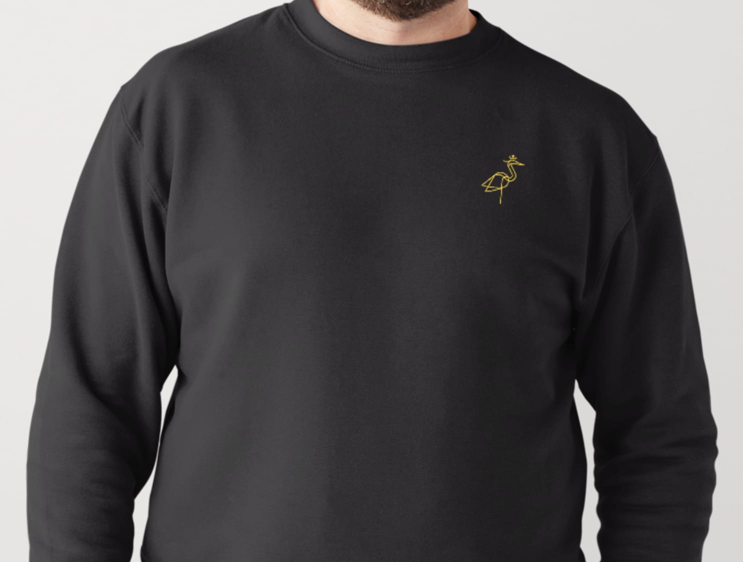 Black sweater product detail with embroidered crest
